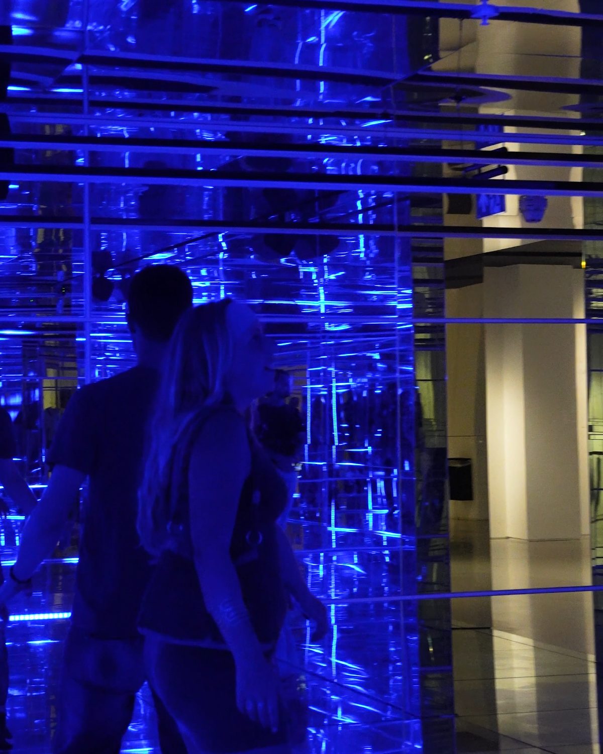 visitors inside a blue mirror room installation