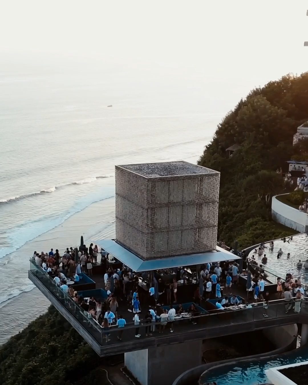 aerial view of a clifftop venue with a cube stage above the sea